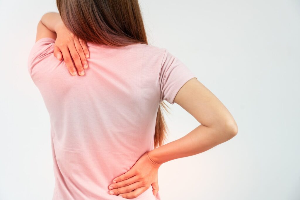 中年女性が腰や肩を痛めている様子